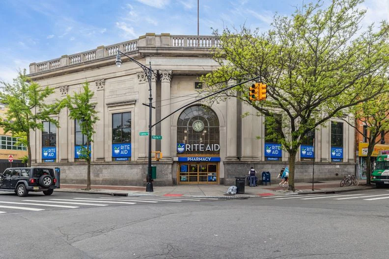 Stone bank building at Myrtle and Cypress Avenues in Ridgewood with Rite Aid signage