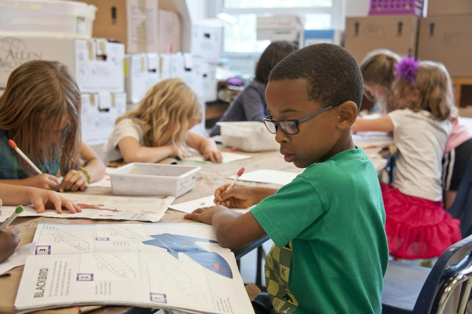 Elementary school students working at tables in a New York City classroom
