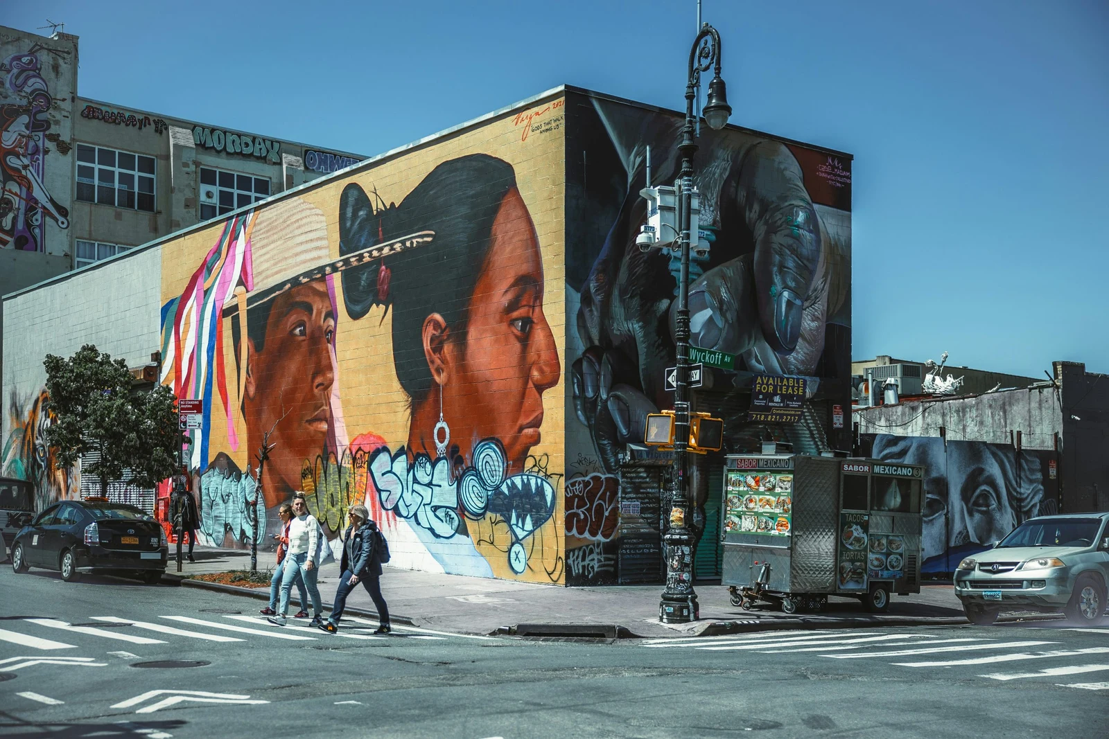 Colorful murals cover a corner building at Wyckoff Avenue in Bushwick